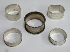 Five hallmarked silver napkin rings, various sizes, designs, makers and dates. Total weight