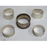 Five hallmarked silver napkin rings, various sizes, designs, makers and dates. Total weight