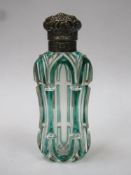 Victorian green overlay cut glass scent bottle, with ornately repousse decorated hinged cap, cap