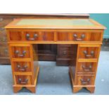 20th century polished yew wood seven drawer pedestal writing desk with green leather insert to top