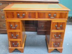 20th century polished yew wood seven drawer pedestal writing desk with green leather insert to top