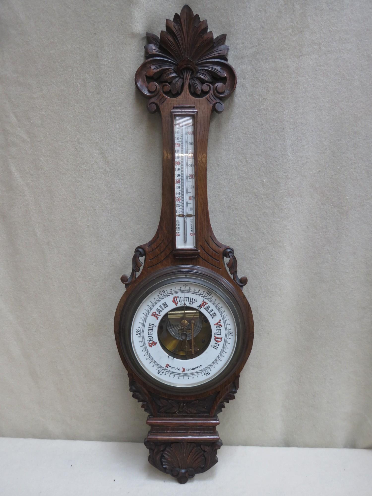 Victorian carved oak cased aneroid banjo barometer, with enamelled skeleton dial and mounted