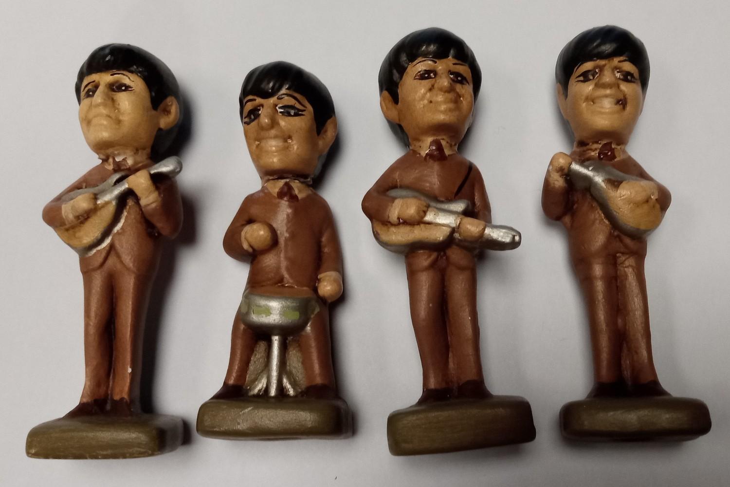 Four small Beatles figures