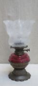 Victorian brass piercework decorated shallow oil lamp, with cranberry glass reservoir and floral