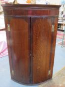 19th century oak and mahogany bow fronted wall mounted corner cupboard. Approx. 104cm H x 67cm W x