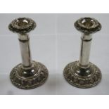 Pair of hallmarked silver candlesticks, with repoussé foliate banded decoration to top and base,