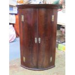 19th century mahogany bow fronted wall mounted corner cupboard, fitted with three drawers inside.