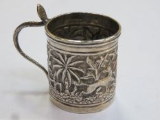 Unhallmarked Indian silver coloured miniature tankard, repousse decorated with a jungle scene.