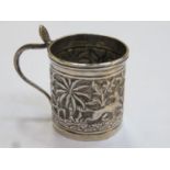 Unhallmarked Indian silver coloured miniature tankard, repousse decorated with a jungle scene.