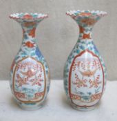 Two similar 19th century handpainted and gilded oriental glazed ceramic crimped rimmed vases, with