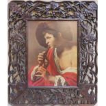 Framed print depicting a young flautist, by Terbrugin ,within heavily carved piercework grape and