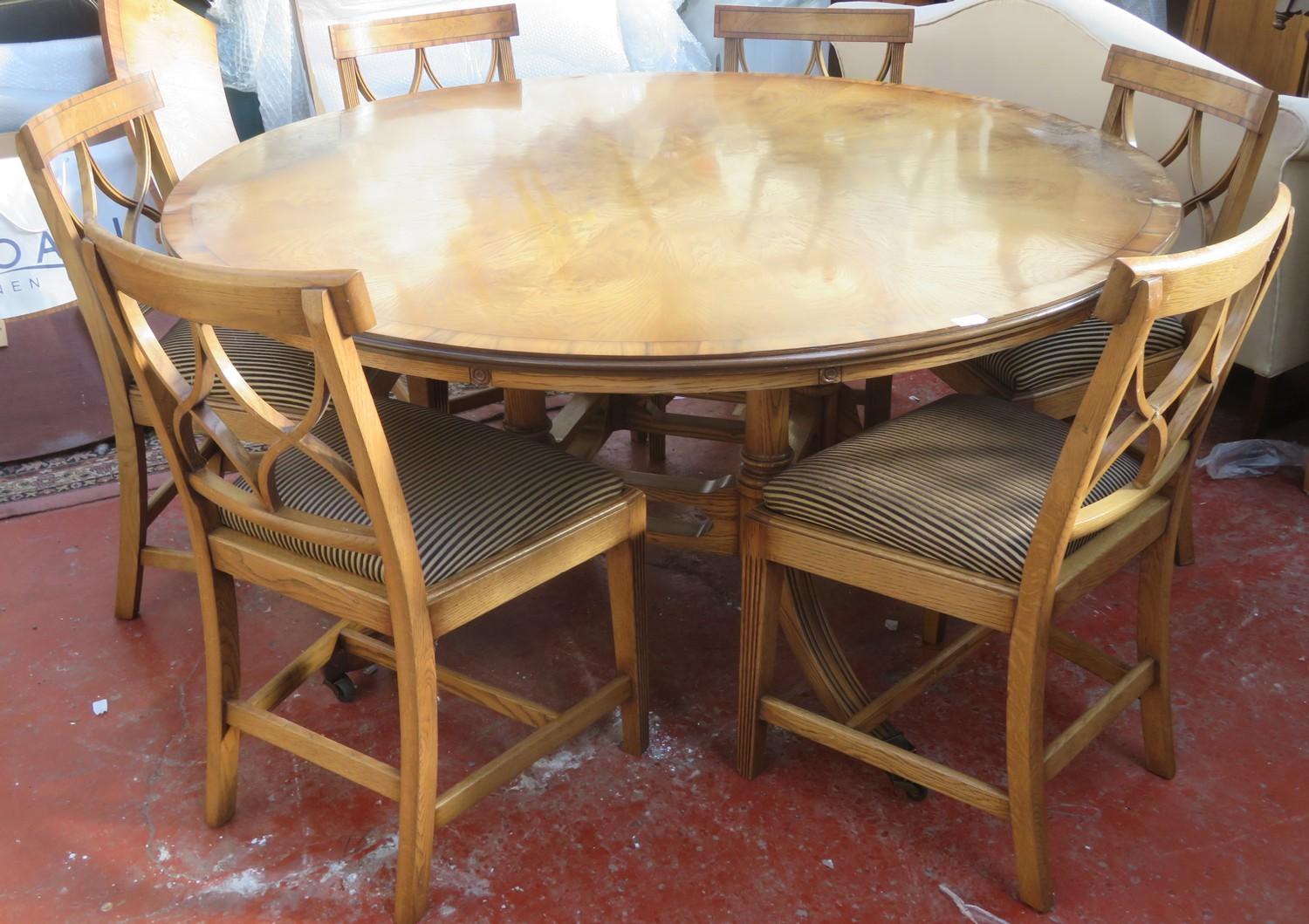 20th century inlaid oak circular topped dining table, on quadrafoil supports, with six curved leaves