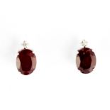 A pair of 900 platinum stud earrings set with oval cut ruby and brilliant cut diamonds, L. 1cm.