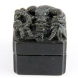 A Chinese carved black soapstone boxed set of artist's seals mounted with a dragon, size 6.5 x 6.5 x