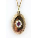 A boxed yellow metal (tested minimum 9ct gold) ruby and diamond set locket pendant and chain.