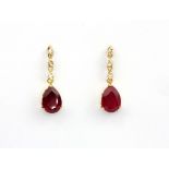 A pair of 18ct yellow gold (stamped 18k) drop earrings set with a pear cut ruby and brilliant cut