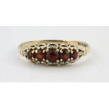 A 9ct yellow gold ring set with garnets, (0.5).