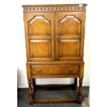 A 1920's carved oak cabinet, W. 76cm H. 140cm.