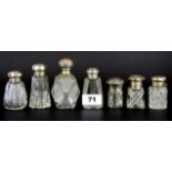 Seven hallmarked silver and cut glass perfume bottles, tallest H. 10cm.