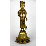 A Tibetan gilt bronze figure of a deity standing on a lotus pedestal, H. 30cm.