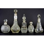 Five hallmarked silver cut glass perfume bottles, tallest H. 21cm.