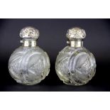 A pair of hallmarked silver topped cut glass perfume bottles, H. 13cm.