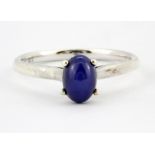 A 9ct white gold ring set with a cabochon star sapphire, (M.5).