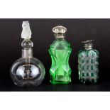 A hallmarked silver rimmed glass perfume bottle together with two white metal topped green glass