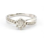 A 9ct white gold diamond set cluster ring with diamond set shoulders, (N).