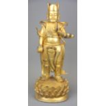 A Tibetan gilt bronze figure of a standing deity, H. 29cm.