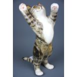 A large Winstanley porcelain figure of a cat with glass eyes, H. 32cm.