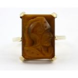 A 9ct yellow gold ring set with carved tiger's eye in the shape of a knight, (O.5).