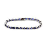 An 18ct white gold (stamped 750) bracelet set with oval cut sapphires and diamonds, L. 18cm.