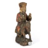 A 19th Century Chinese painted carved wooden ancestor figure riding a horse, H. 34cm.