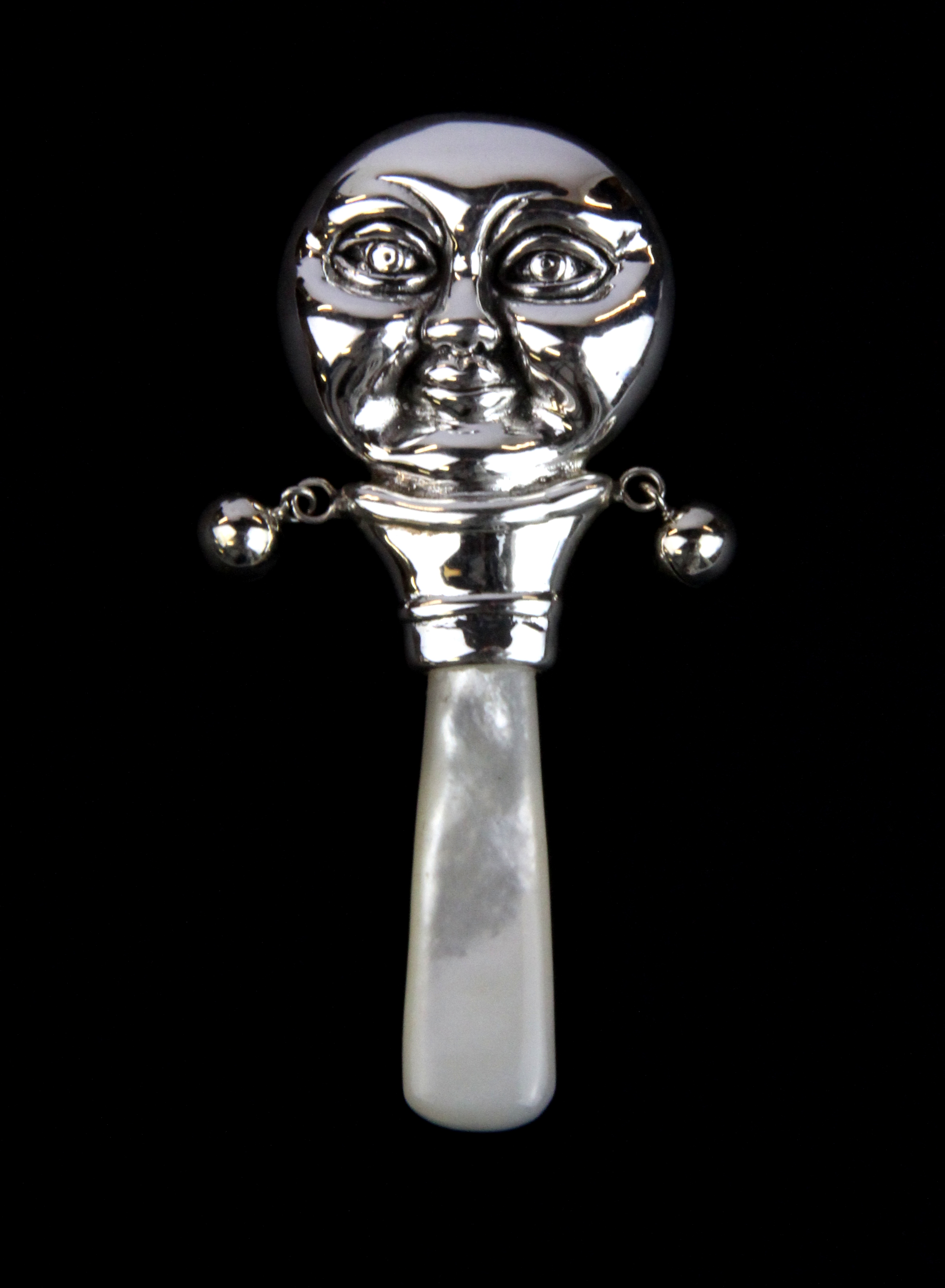 A sterling silver and mother of pearl man in the moon baby rattle, L. 8cm.