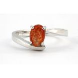 A 9ct white gold ring set with a cabochon cut sandstone, (N.5).