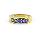 An 18ct yellow gold ring set with oval cut tanzanites, (L).