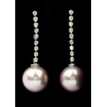 A pair of 18ct white gold (stamped 18k) drop earrings set with a large pink pearl and brilliant