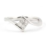 An 18ct white gold crossover ring set with princess cut diamonds, (M.5).