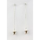 A pair of 18ct white gold diamond set star shaped drop earrings, L. 5cm.