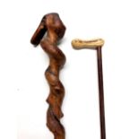 A large twisted wooden walking stick together with a metal peanut handled '19 Jimmy Carter 76'