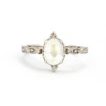A 9ct white gold (stampoed 10k) ring set with a cabochon cut moonstone and diamonds, (Q.5).