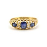 An 18ct yellow gold ring set with oval cut sapphires and rose cut diamonds, (O.5).