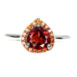 A 925 silver cluster ring set with a pear cut garnet surrounded by orange sapphires, (N.5).
