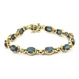 A 14ct yellow gold (stamped 14k) bracelet set with London blue topaz, L. 19cm.