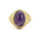 A 9ct yellow gold ring set with a cabochon cut amethyst, (N).