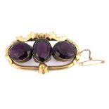 A Victorian rolled gold brooch set with three large oval cut amethysts, 6 x 3.5cm.