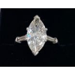 A platinum ring set with a 3ct marquise cut centre diamond with baguette cut diamond set