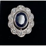 An 18ct white gold large cluster ring set with an oval cut sapphire and brilliant cut diamonds, L.