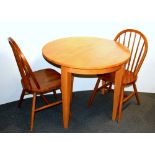 A folding beechwood breakfast table and two chairs, Dia. 91cm.